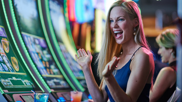 Woman playing slot machine and winning jackpot